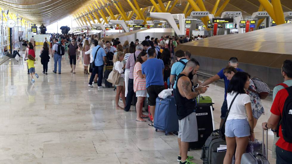 Un grupo de pasajeros hacen cola para facturar en la T-4 del aeropuerto Adolfo Suárez (Madrid)