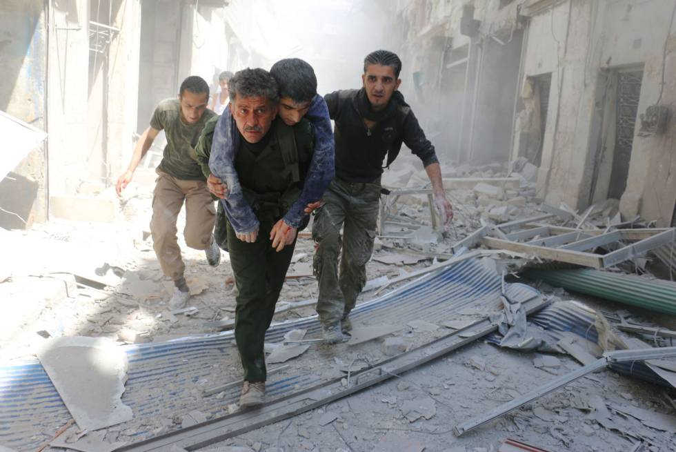 Varios hombres evacuan a un hombre herido tras un bombardeo en un vecindario al norte de Alepo, este viernes. 