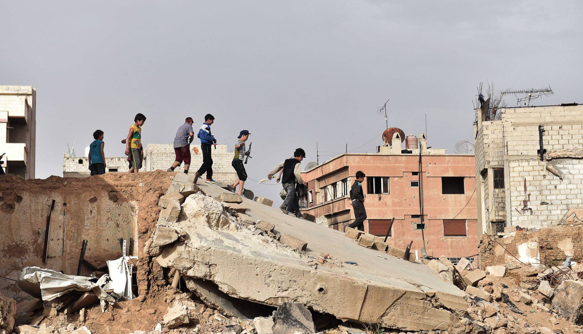 Un grupo de niños juega sobre las ruinas de un edificio al sur de Damasco. Un grupo de niños juega sobre las ruinas de un edificio al sur de Damasco.