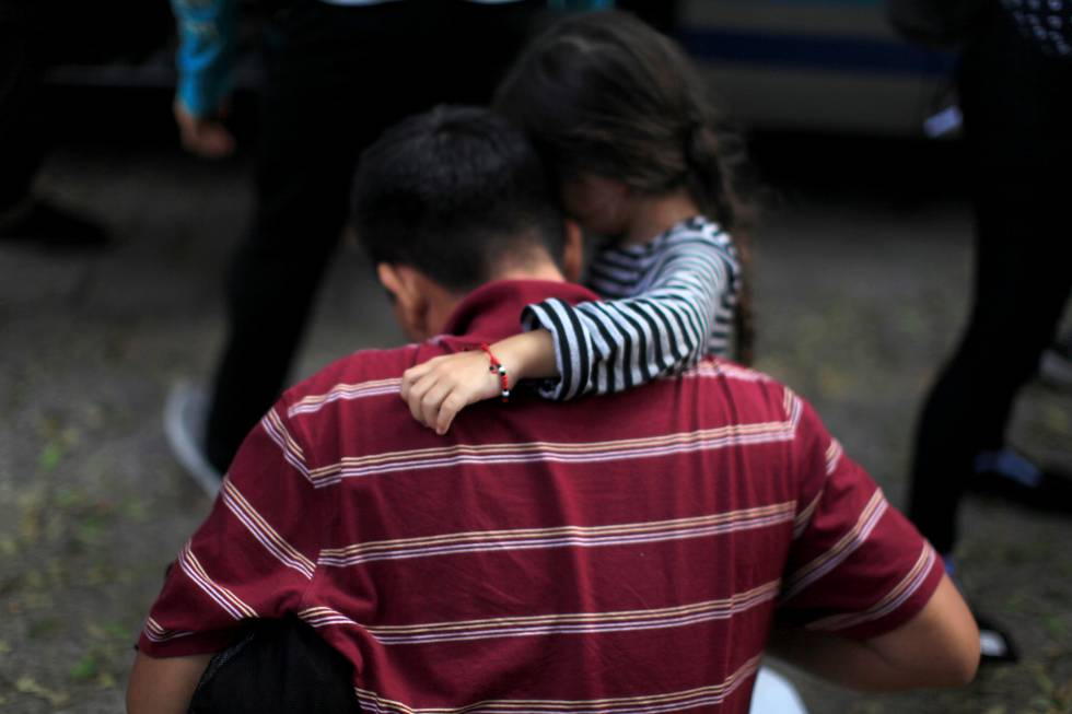 Una niña abraza a su padre tras ser deportados de México a San Salvador.