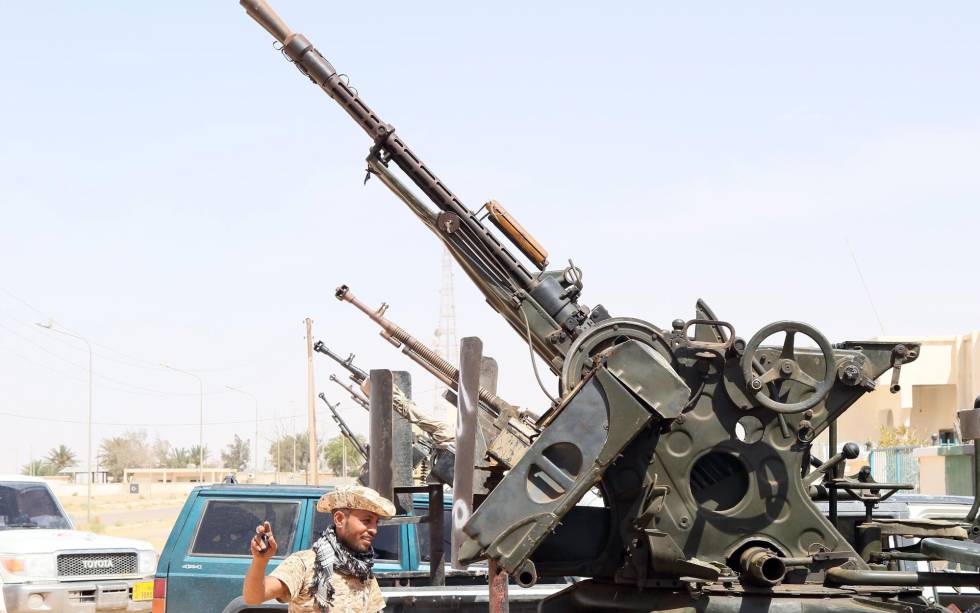 Un miembro de las milicias libias leales al Gobierno de Unidad, delante de varias armas situadas en el puesto de control de Abú Grain, al este de Misrata, el 18 de mayo.rn Un miembro de las milicias libias leales al Gobierno de Unidad, delante de varias armas situadas en el puesto de control de Abú Grain, al este de Misrata, el 18 de mayo.rn