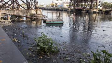 Las aguas de la cuenca tienen basura flotando que se acumula en los bordes.