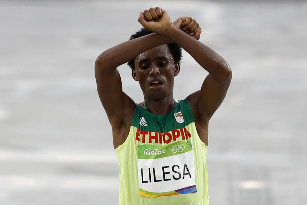 Feyisa Lilesa realiza su gesto crítico al llegar a la meta.