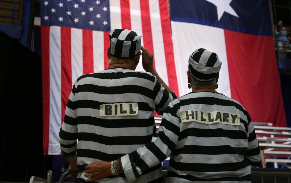 Dos seguidores de Trump disfrazados de presos con los nombres de Bill y Hillary. El lema
