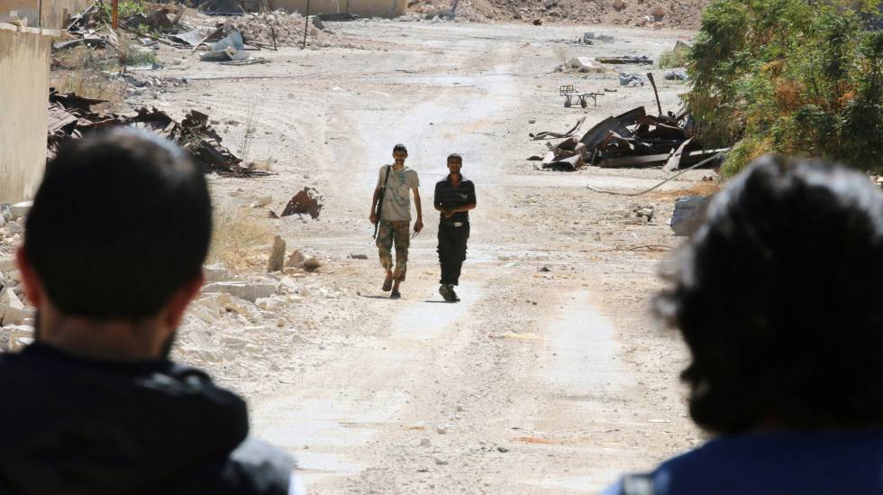 Rebeldes sirios montan guardia en la principal vía de acceso a Alepo.