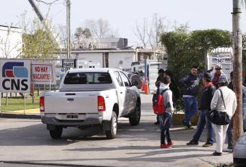 Operarios esperan frente al obrador del tren para su primer día de trabajo.