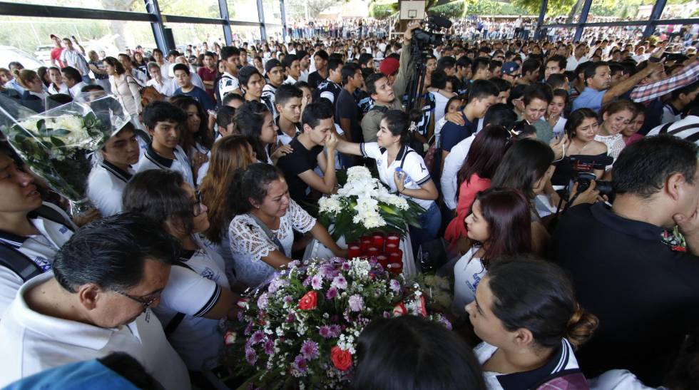 Amigos y compañeros de las víctimas en su funeral.