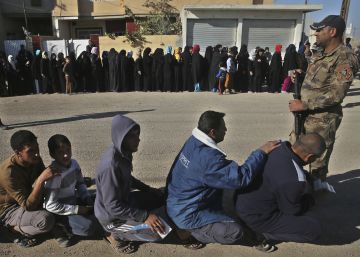 CIudadanos iraqu&iacute;es esperan para recibir v&iacute;veres en el barrio de al-Arbajiyeh, en Mosul (Iraq), el pasado 19 de noviembre.