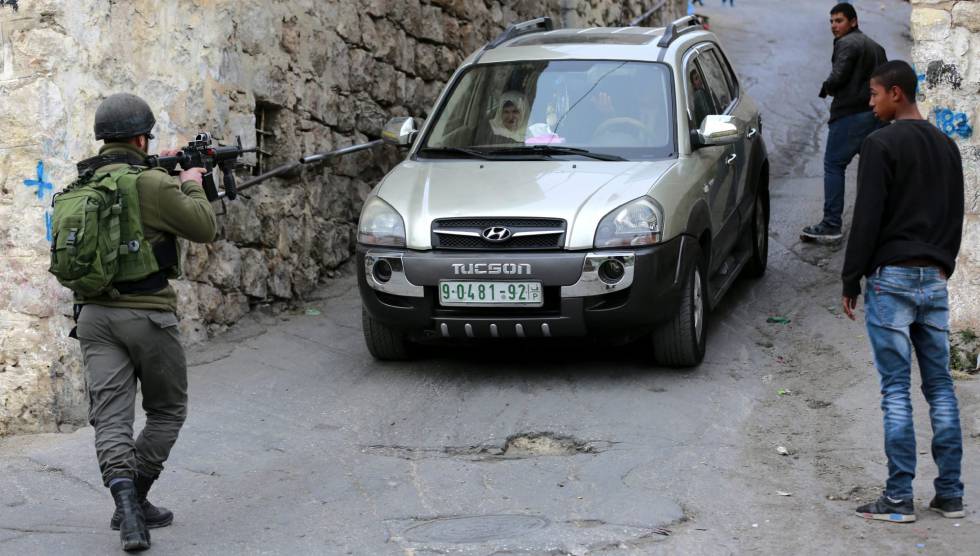 Un soldado israelí detiene un vehículo palestino en Hebrón, este martes.