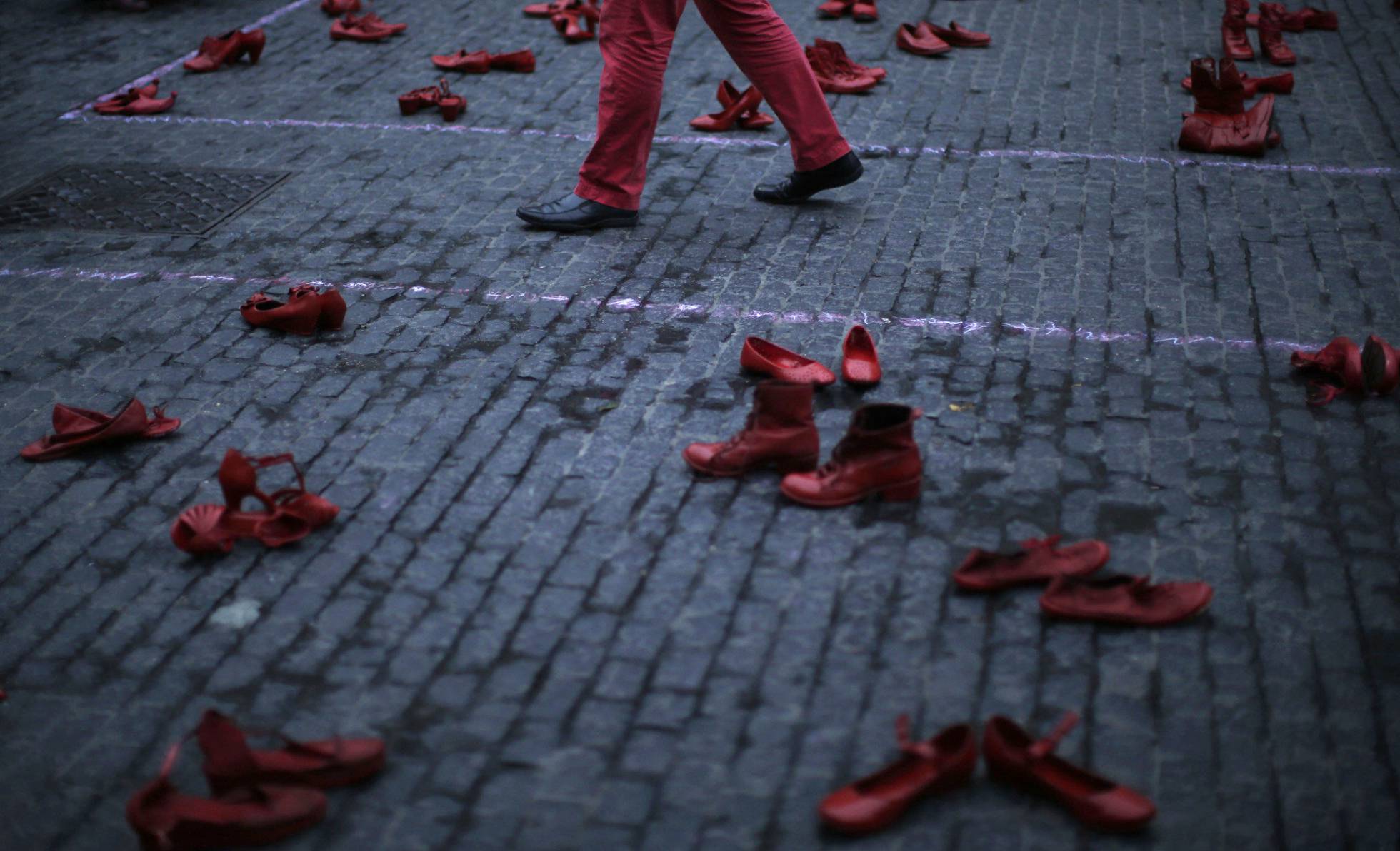 Un hombre camina entre zapatos femeninos en una protesta contra la violencia machista en Barcelona (España), este lunes. Un hombre camina entre zapatos femeninos en una protesta contra la violencia machista en Barcelona (España), este lunes.