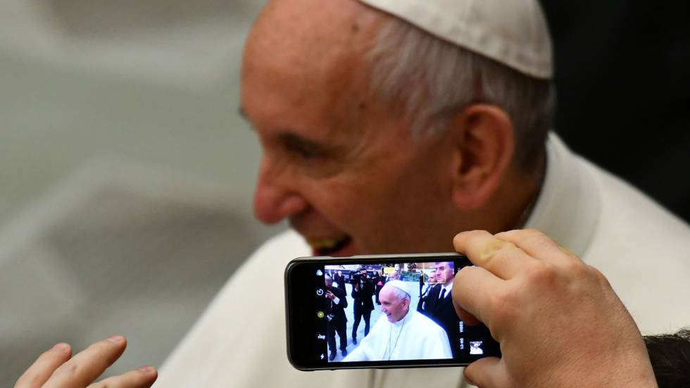 Una persona toma una foto del papa Francisco con un teléfono móvil.
