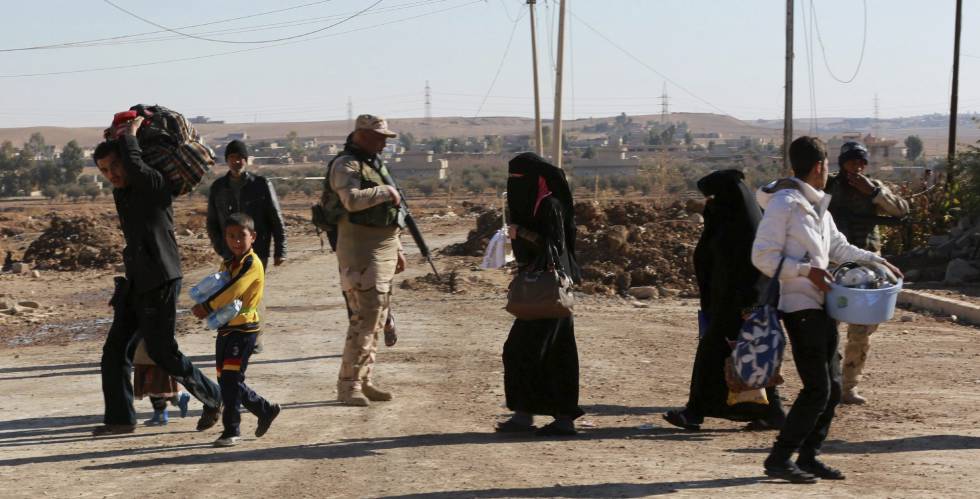 Soldados iraquíes evacuan a civiles durante los enfrentamientos con miembros del Estado Islámico al sureste de Mosul.