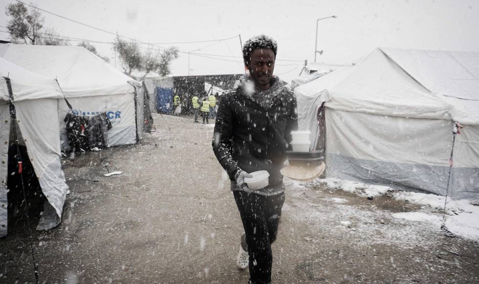 Un migrante del campamento de Moria, en la isla griega de Lesbos, caminaba ayer hacia su tienda con un recipiente de comida.