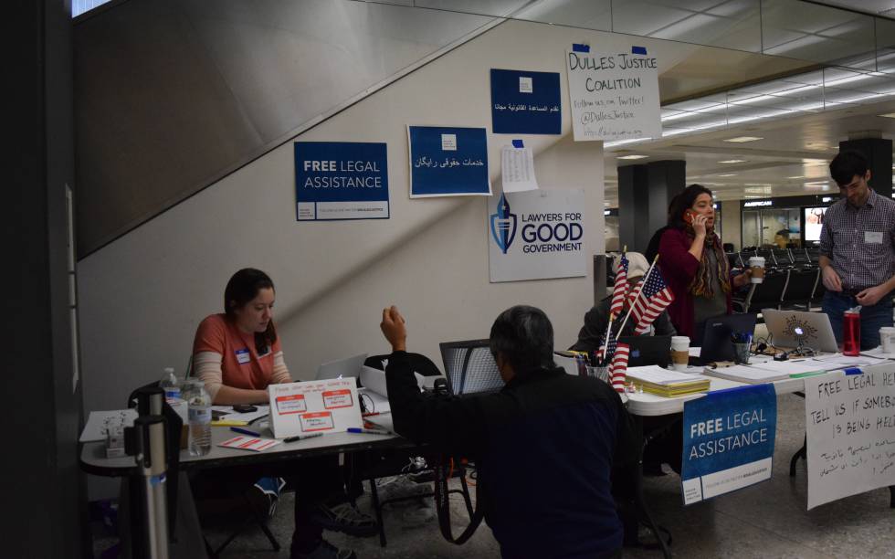 Varios abogados, el pasado sábado, en la mesa que han instalado en el aeropuerto de Dulles. Fotografía facilitada por la abogada Ofelia Calderón, la mujer que aparece de pie