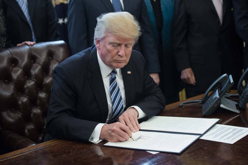 Donald Trump firma una orden ejecutiva en la Casa Blanca.