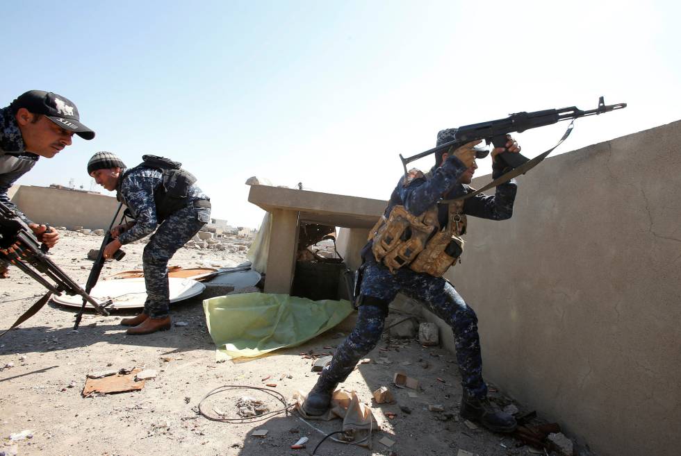 Un pollicía federal iraquí dispara su rifle en un distrito de la ciudad vieja de Mosul, este domingo