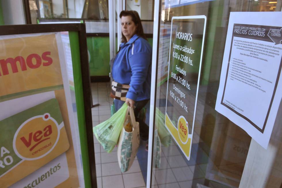 Una mujer sale con una bolsa cargada de productos de un supermercado en Buenos Aires.