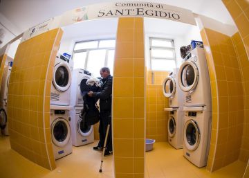 Un hombre mete ropa en una secadora en la lavandería inaugurada el lunes en Roma. 