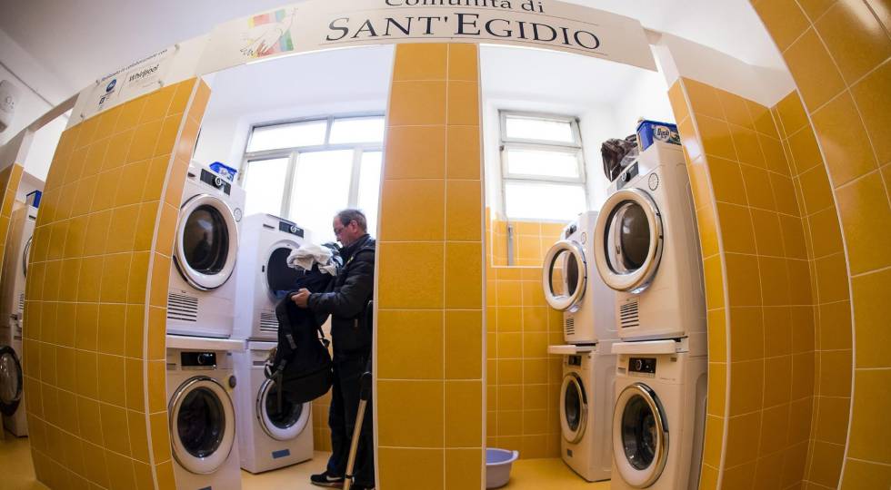 Un hombre mete ropa en una secadora en la lavandería inaugurada el lunes en Roma.