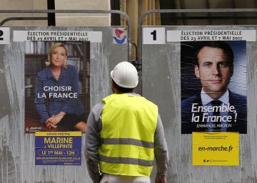 Un obrero observa los carteles de los candidatos a la segunda vuelta en Francia