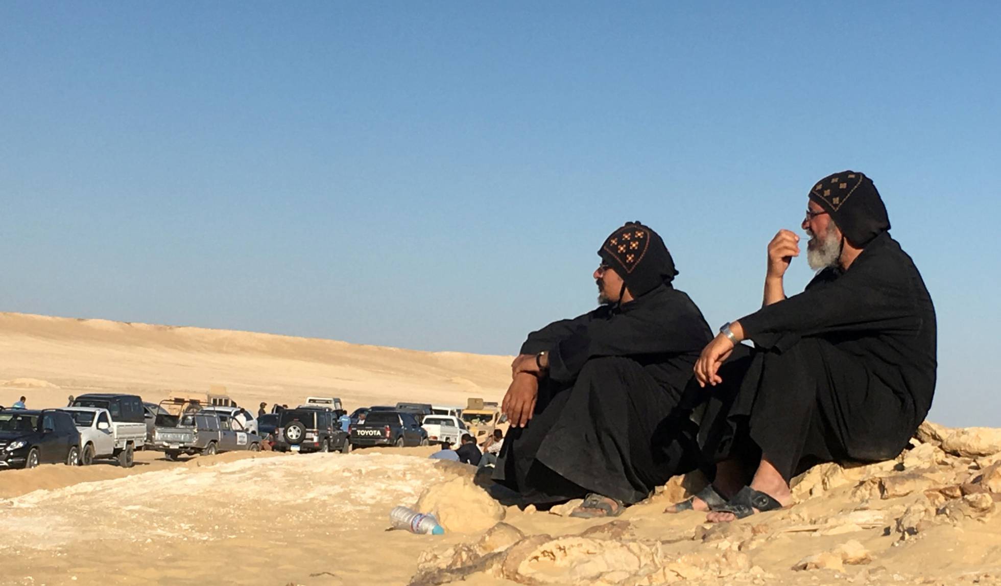Dos hombres sentados tras el atentado de este viernes contra un grupo de coptos que viajaban a un monasterio al sur de Egipto. rn