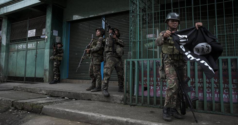 Un soldado filipino retira una bandera del ISIS de una calle de Marawi, este fin de semana.