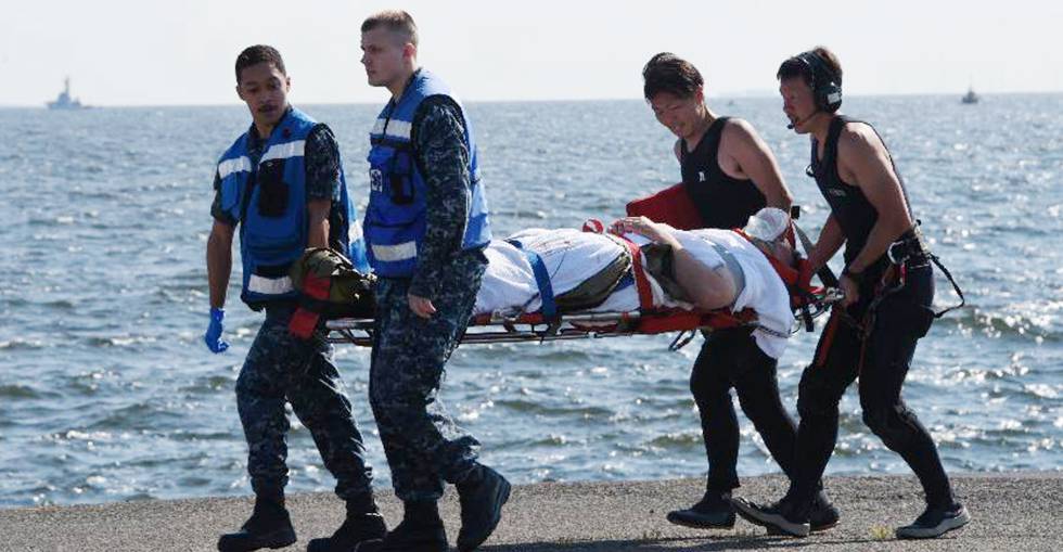 Militares americanos e japoneses evacuam um dos marinheiros feridos
