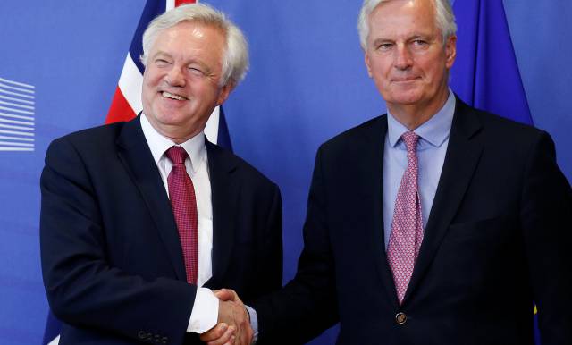 Barnier y Davis se saludan antes de comenzar la reunión en Bruselas.
