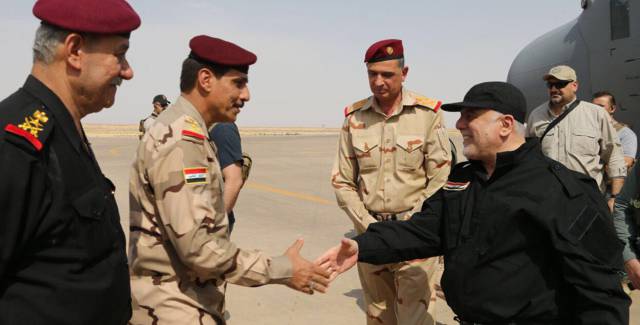 El primer ministro iraquí, Haider al-Abadi, saluda a oficiales de la policía y el ejército este domingo a su llegada a Mosul.