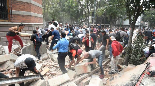 Varias personas retiran escombros de un edificio destruido a causa del terremoto, en Ciudad de México.