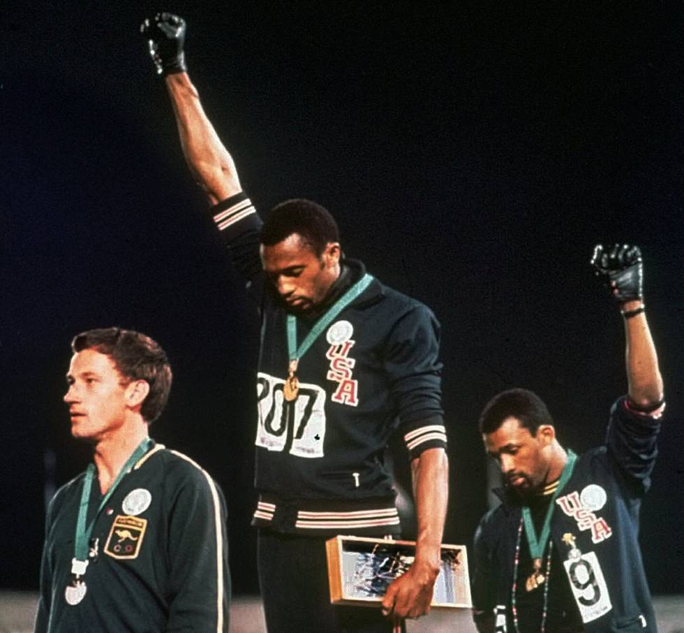 Los atletas Tommie Smith, en el centro, y John Carlos, alzan el puño en los Juegos Olímpicos de México de 1968