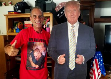 Gene Huber posa junto a un recorte de Trump de tamaño real en el salón de su casa.