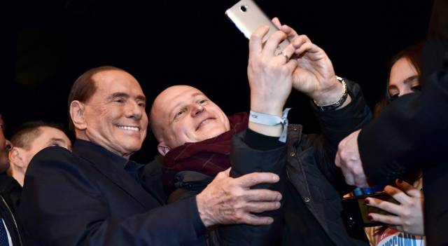 El empresario y ex primer ministro, Silvio Berlusconi, se fotografía con un seguidor en Milán.