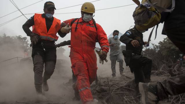Bomberos y policías evacuan una zona de rescate en Escuintla, Guatemala.