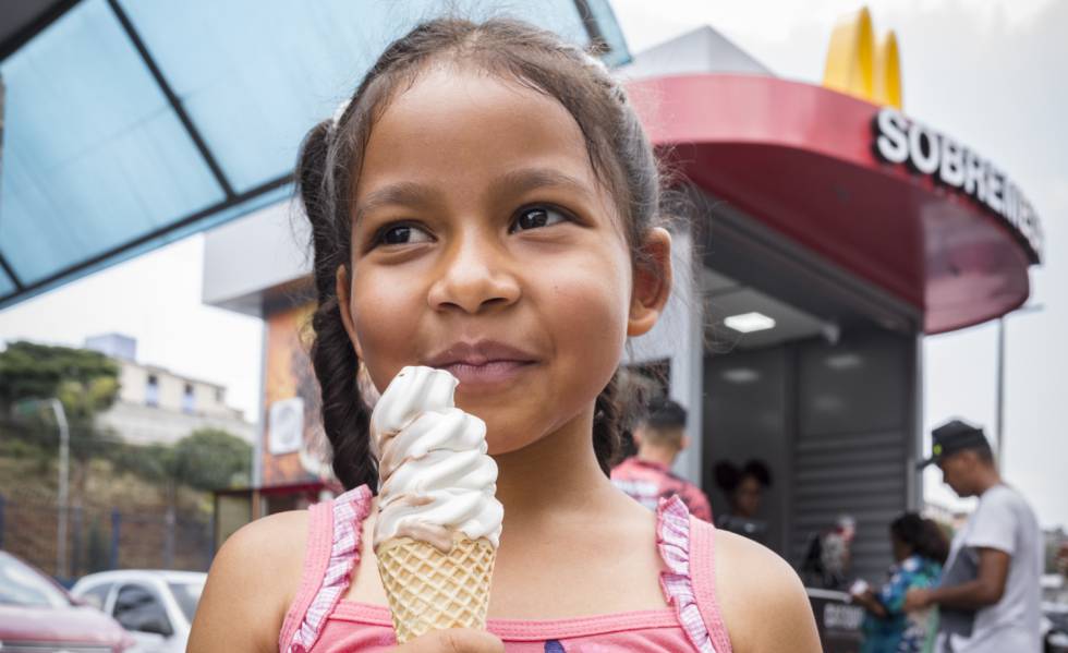 Uma criança prova um gelado uma manhã de novembro em Cidade Tiradentes
