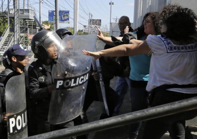 Antidisturbios de la Policía nicaragüense dispersan a los informadores, este sábado en Managua.