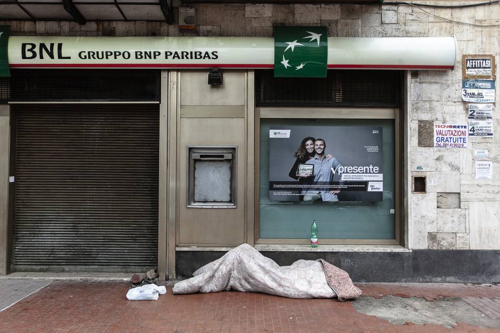 Un sin techo duerme en la calle en el barrio napolitano de Bagnoli.