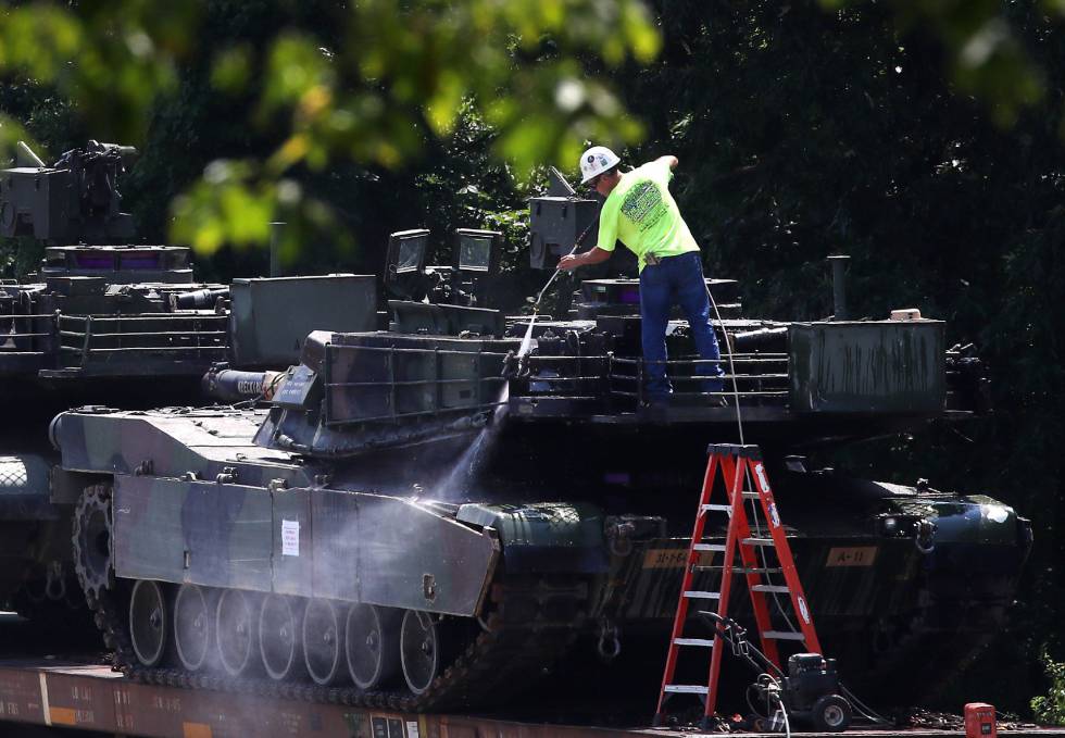 Un trabajador limpia uno de los dos tanques M1A1 Abrams.