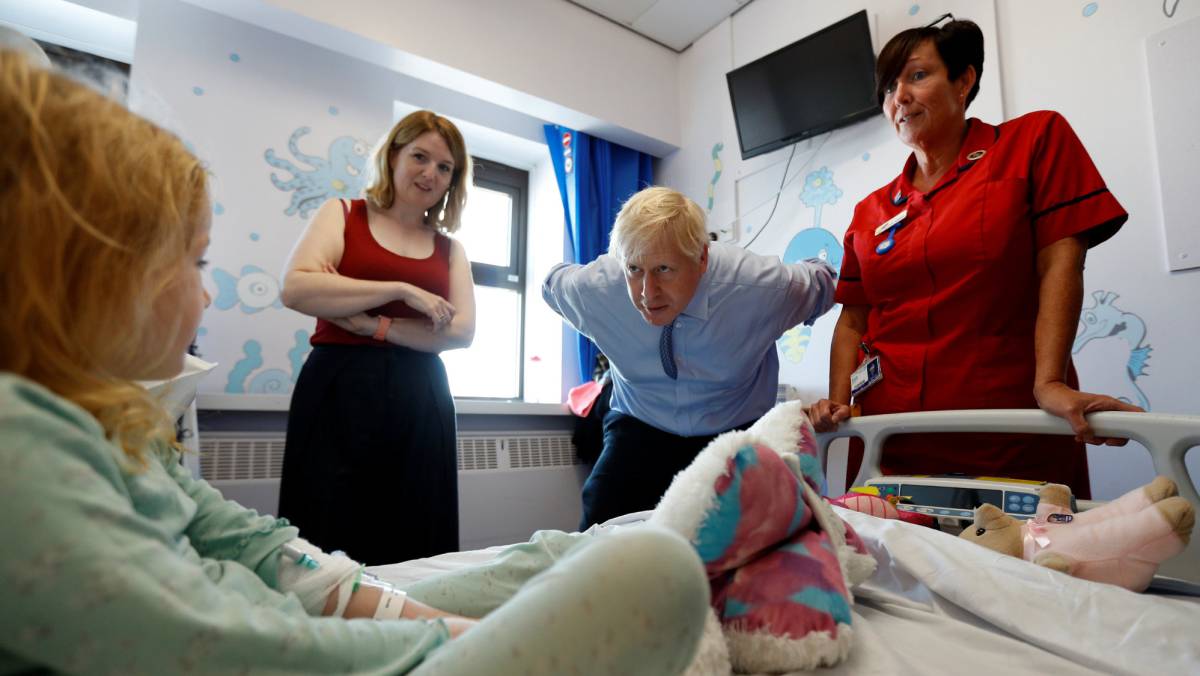 El primer ministro británico, Boris Johnson, el lunes con una paciente de cinco años durante su visita a un hospital en Truro (Inglaterra).
