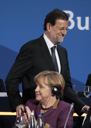 Merkel aplaude a Rajoy tras su intervención.