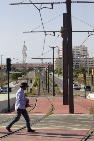 Un paseante atraviesa las vías del tranvía. rn rn Un paseante atraviesa las vías del tranvía. rn rn