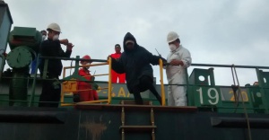 Un inmigrante baja del mercante que encontró a una de las pateras.