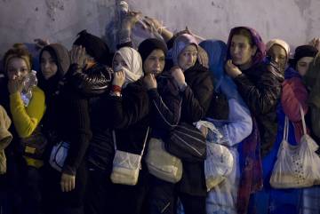 Mujeres, poco antes del alba, apretujadas en la frontera.