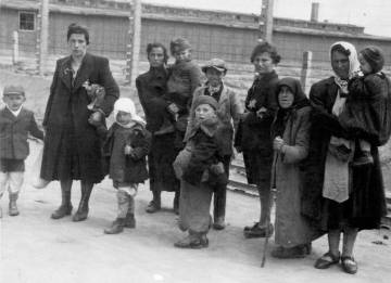 Mujeres judías con sus niños caminan hacia las cámaras de gas ignorando la suerte que les espera.