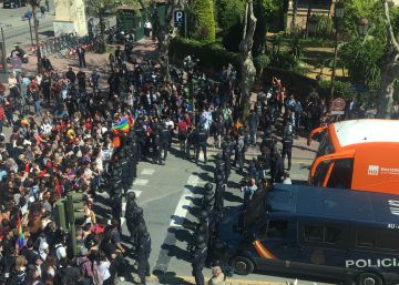 La policía custodia el autobús de Hazte Oír frente a los manifestantes que bloquean su paso en Sevilla.