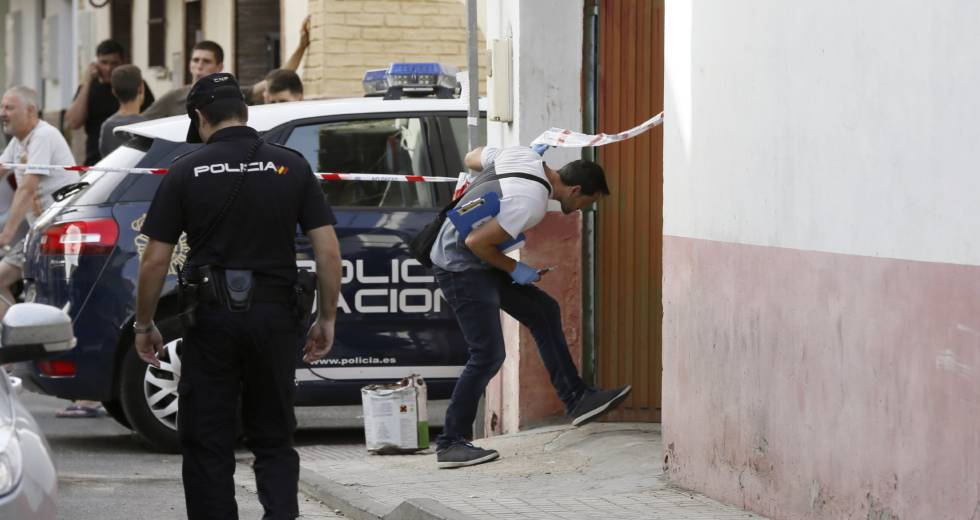 Policías junto a la vivienda donde ha sido asesinada una mujer este sábado en Sevilla.