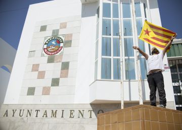 Un operario del Ayuntamiento de Marinnaleda (Sevilla) iza una bandera estelada independentista catalana.
