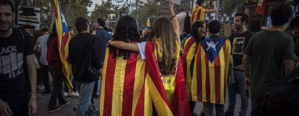 Two girls, one with a Catalan independence flag wrapped on her shoulders walks together with another one with a Spanish flag as demonstrators gather in downtown Barcelona, Spain, Tuesday Oct. 3, 2017. Thousands of people are demonstrated in Barcelona in protest at what they say was police brutality during a referendum on Catalonia's secession from Spain that was previously declared illegal by Spain's Constitutional Court.(AP PhotoSanti Palacios)