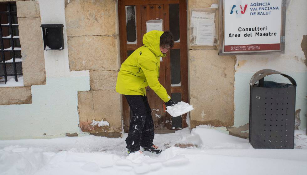 Un joven limpia el acceso al centro de salud en Ares del Maestre, Castellón.