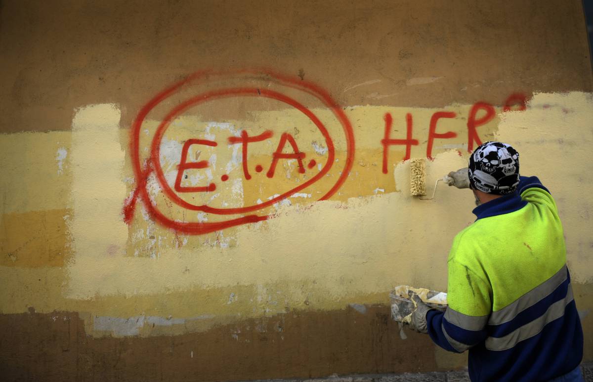 Un trabajador municipal borra una pintada con la leyenda